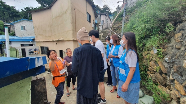 부산 동구 수해가구 세대를 방문해 이야기를 주민들의 이야기를 듣고 있는 대표 채환과 자원봉사자들